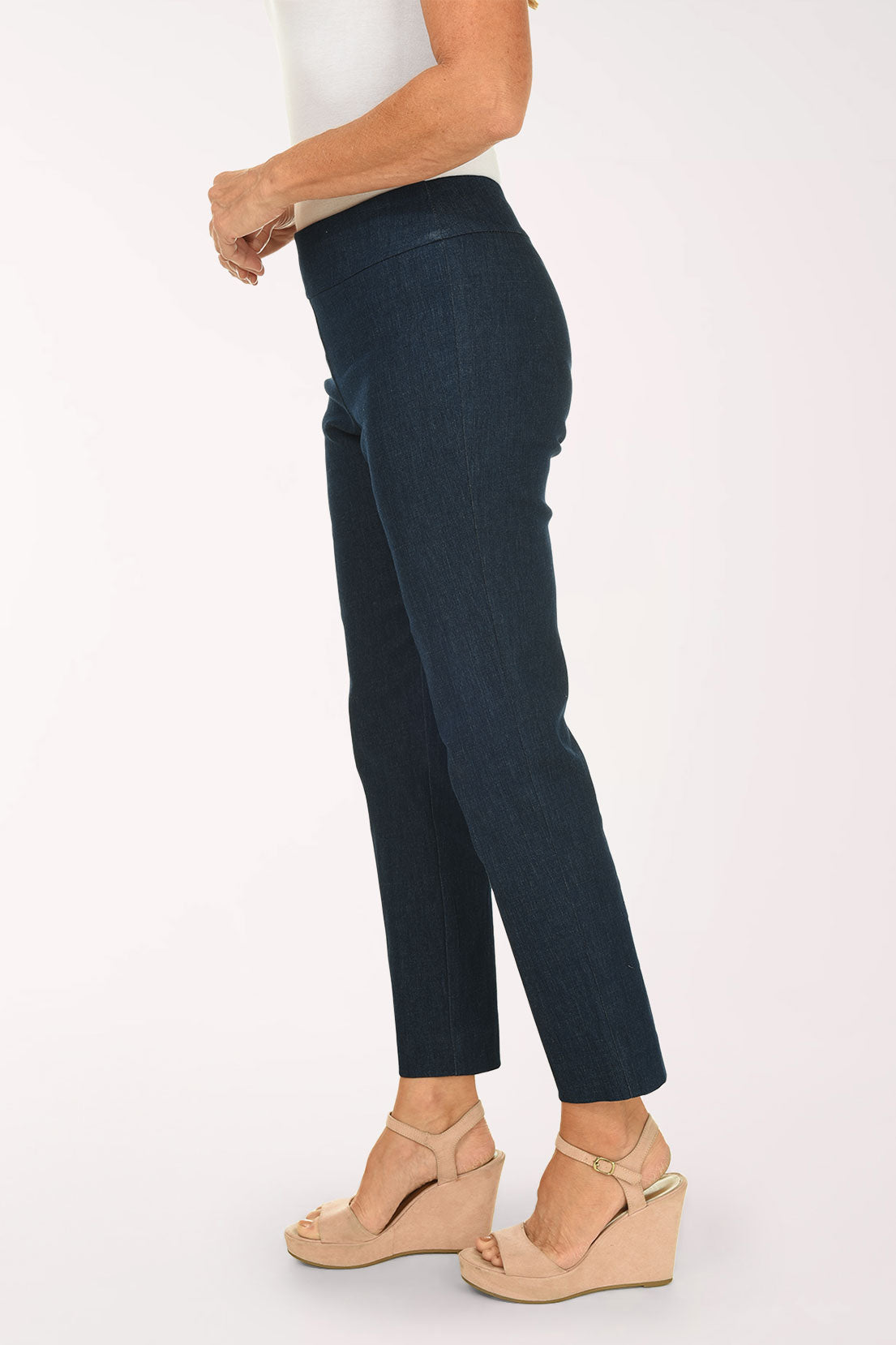 Dark blue jeans worn by a person on a white background