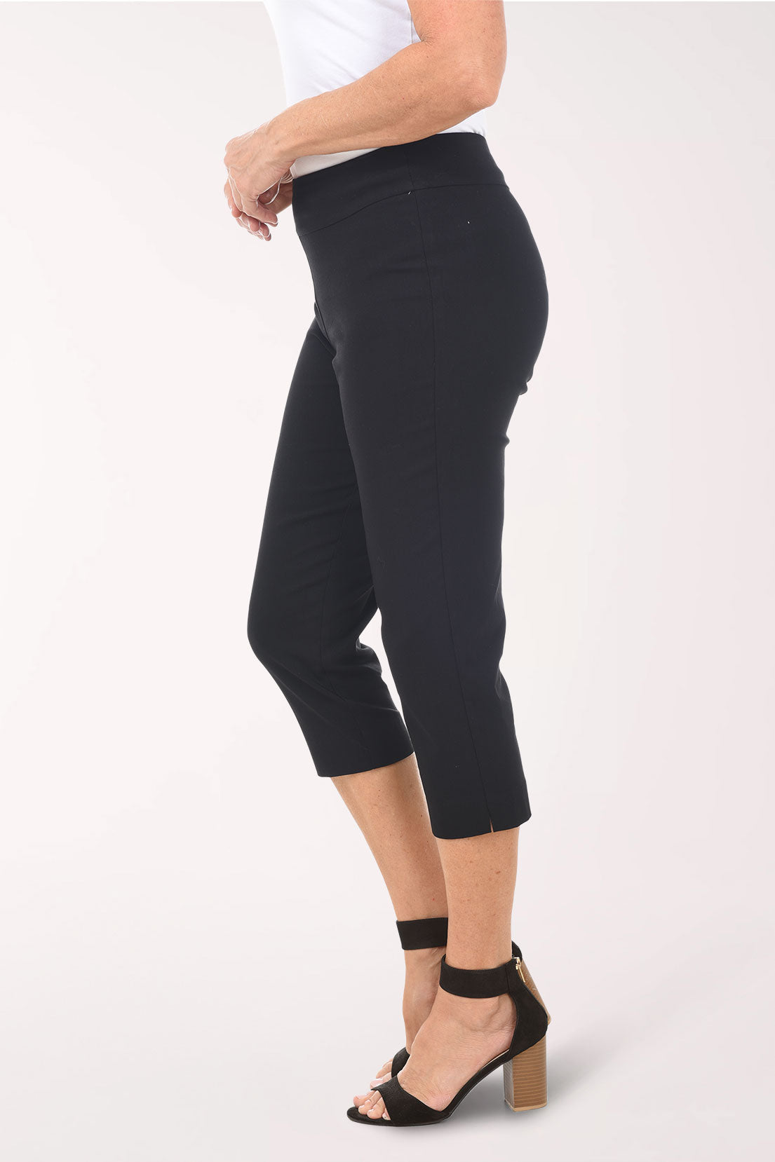 Person wearing black capri pants on a white background