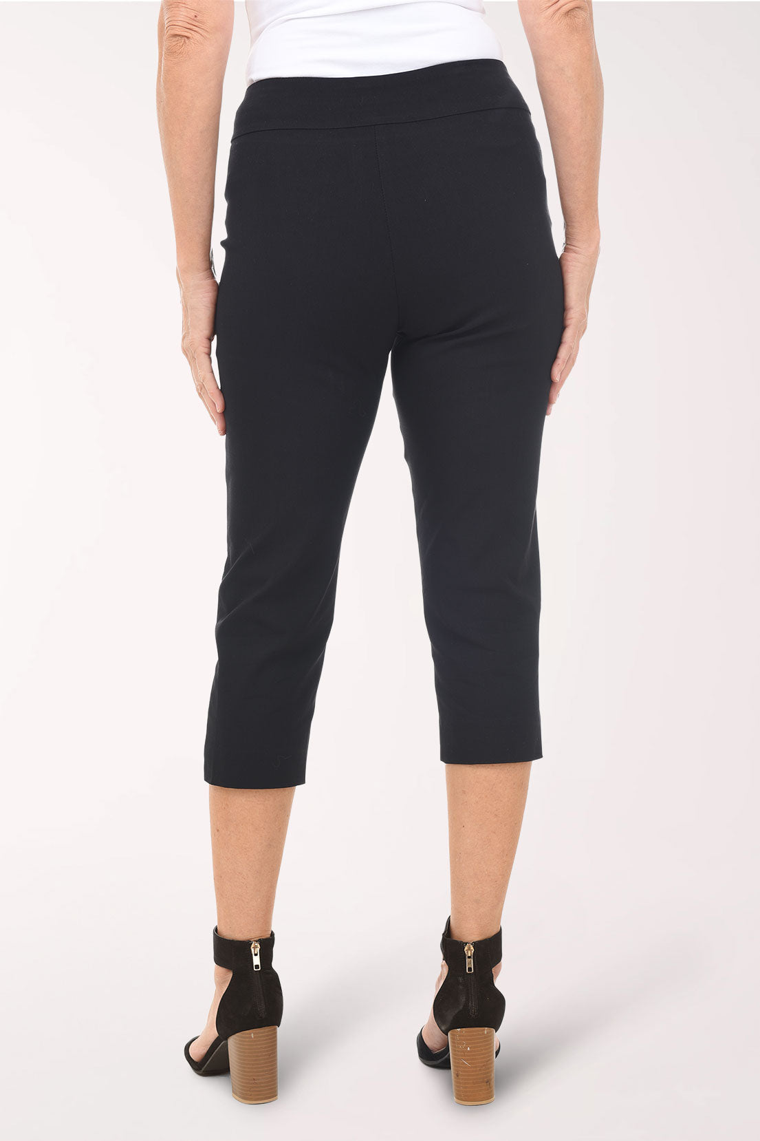 Black capri pants worn by a person on a white background