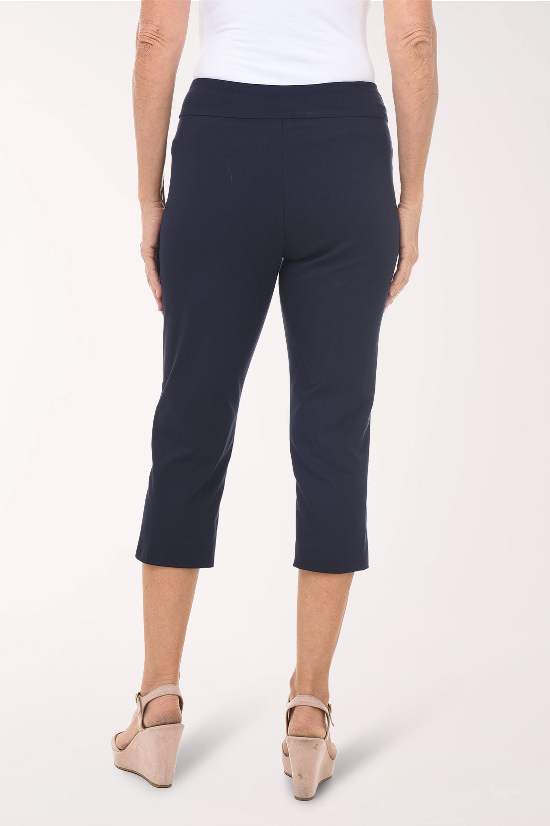 Person wearing navy capri pants on a white background