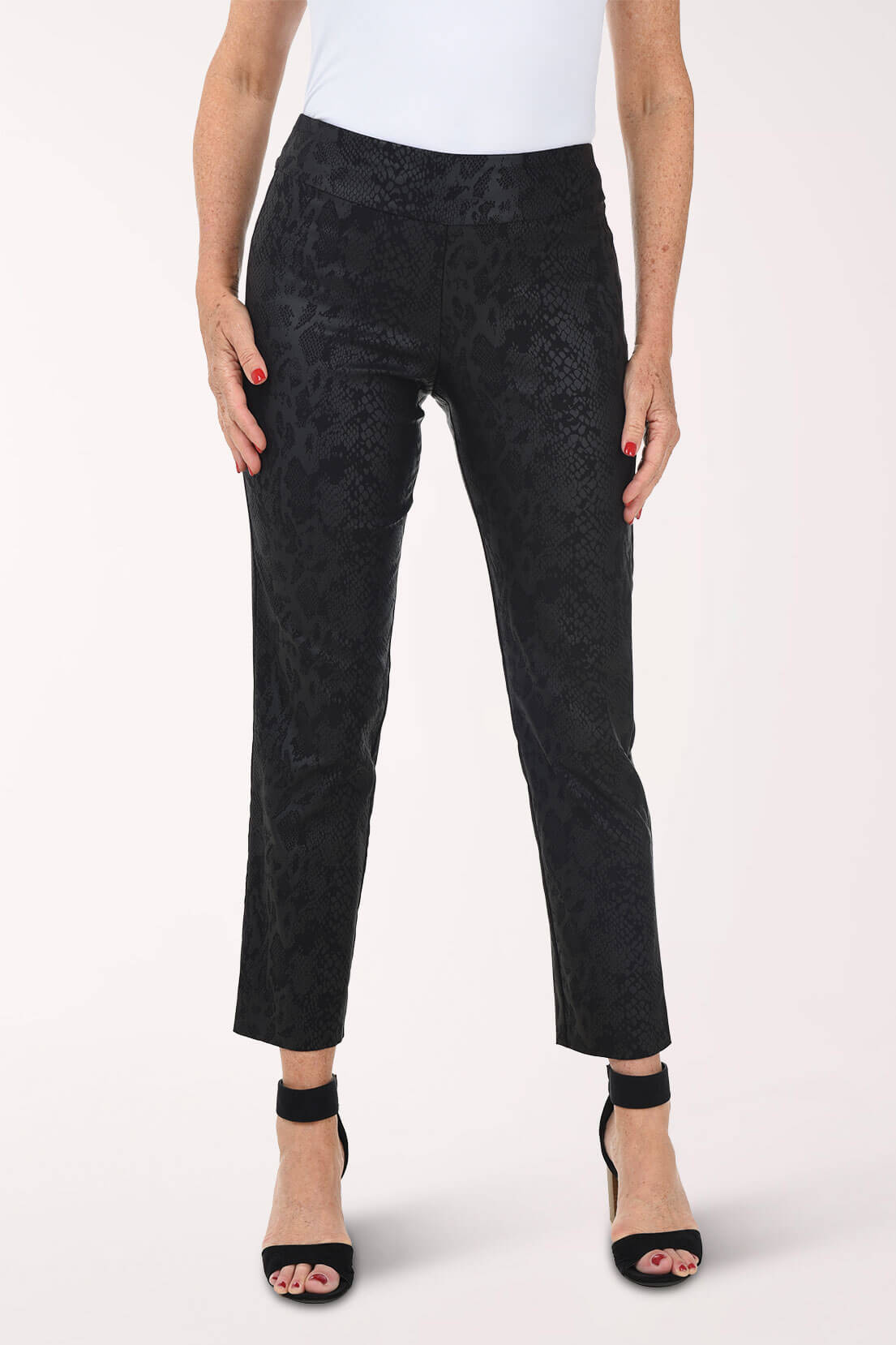 Person wearing black patterned pants on a white background