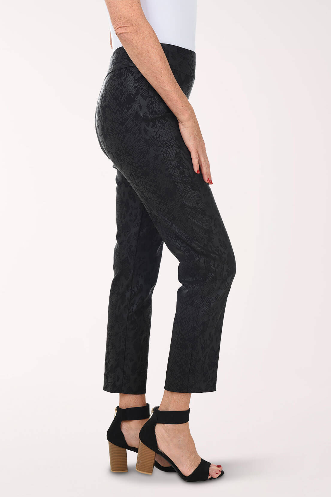 Person wearing black patterned pants on a white background