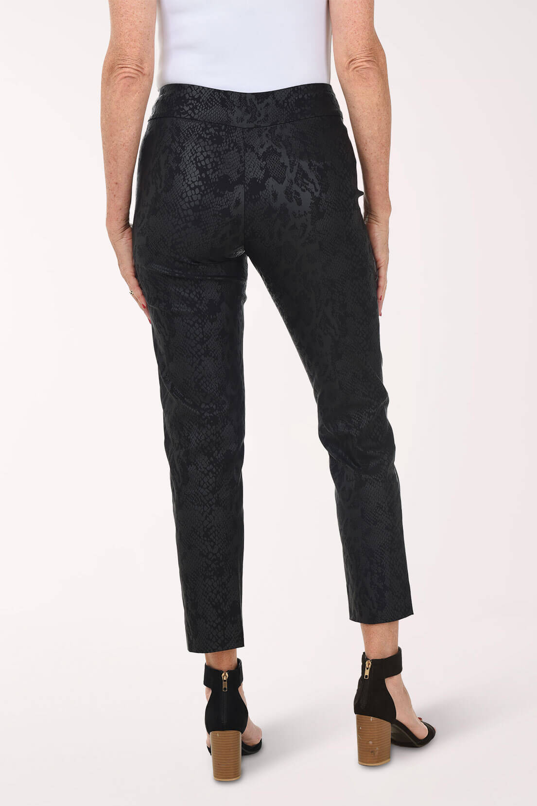 Person wearing black patterned pants on a white background