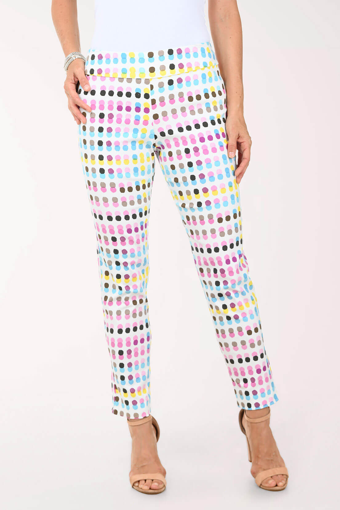 Multicolored polka dot pants worn by a person on a white background