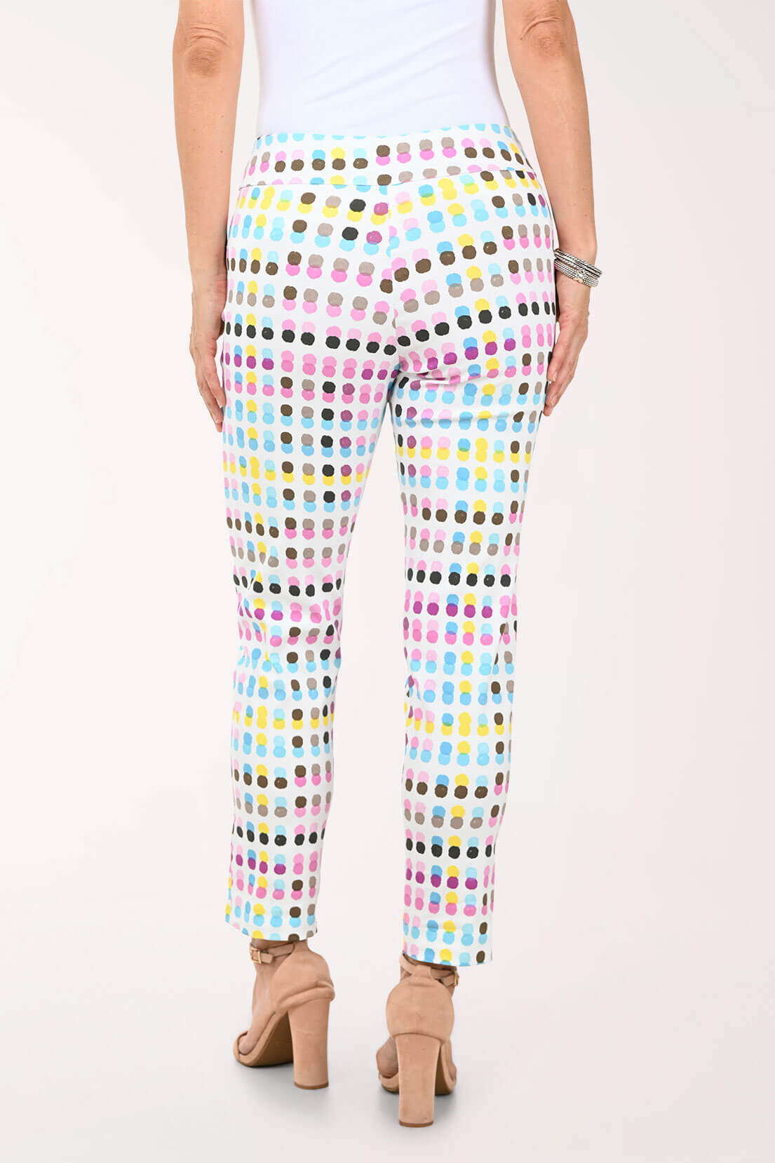 Multicolored polka dot pants worn by a person on a white background
