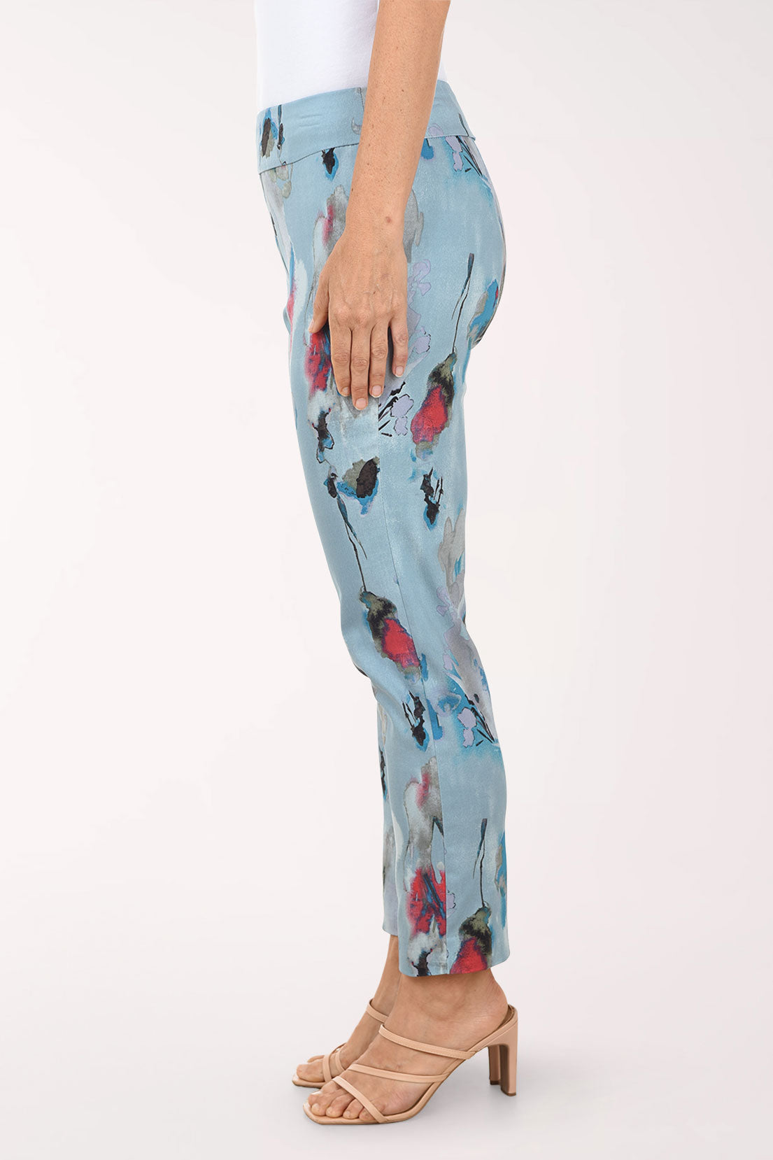 Light blue pants with colorful floral pattern worn by a person on a white background