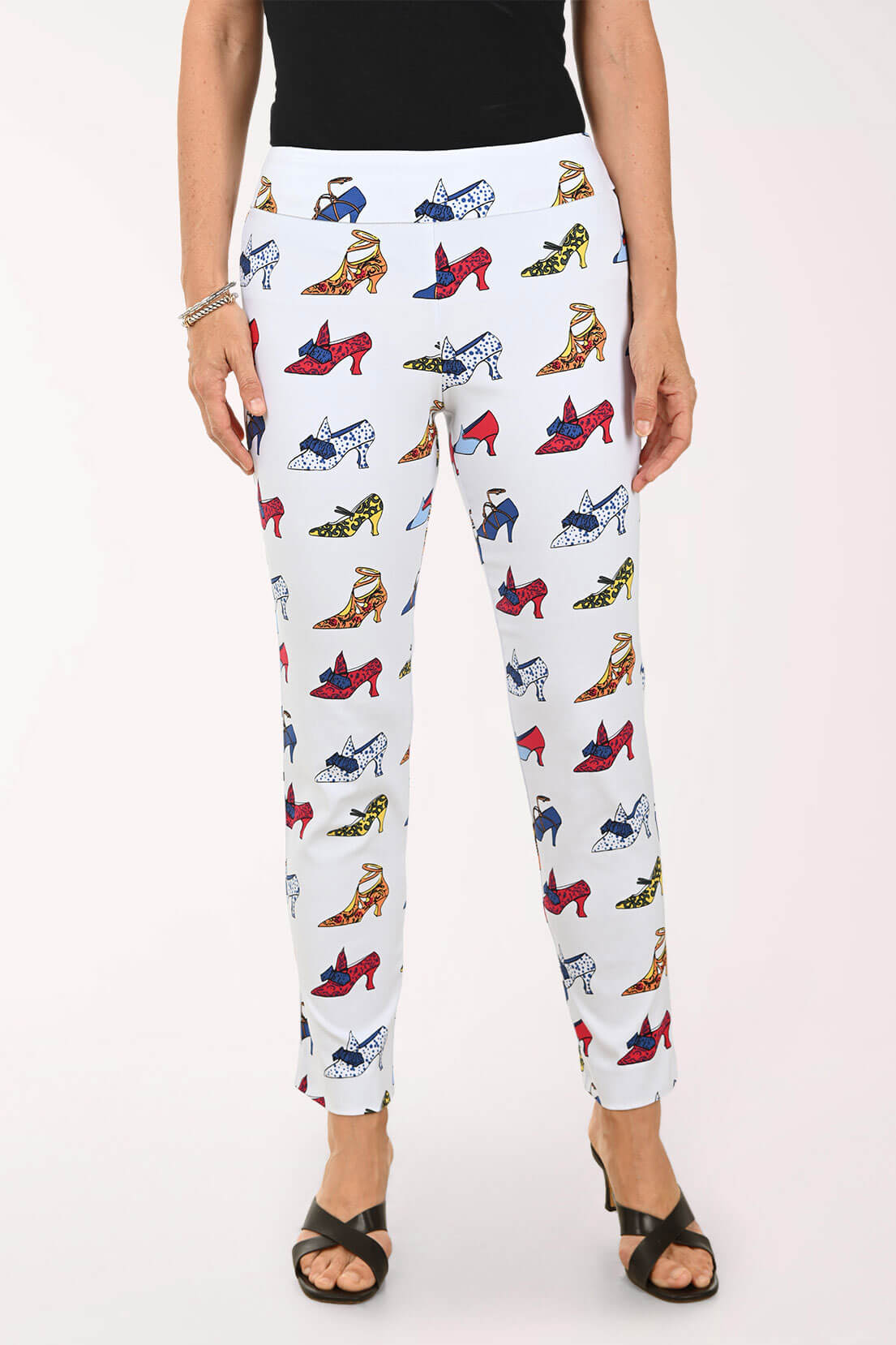White pants with colorful high heel print worn by a person on a white background