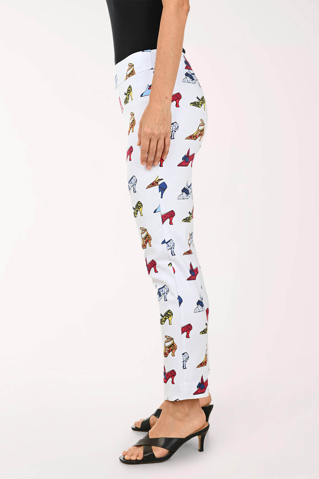 White pants with colorful high heel print worn by a person on a white background