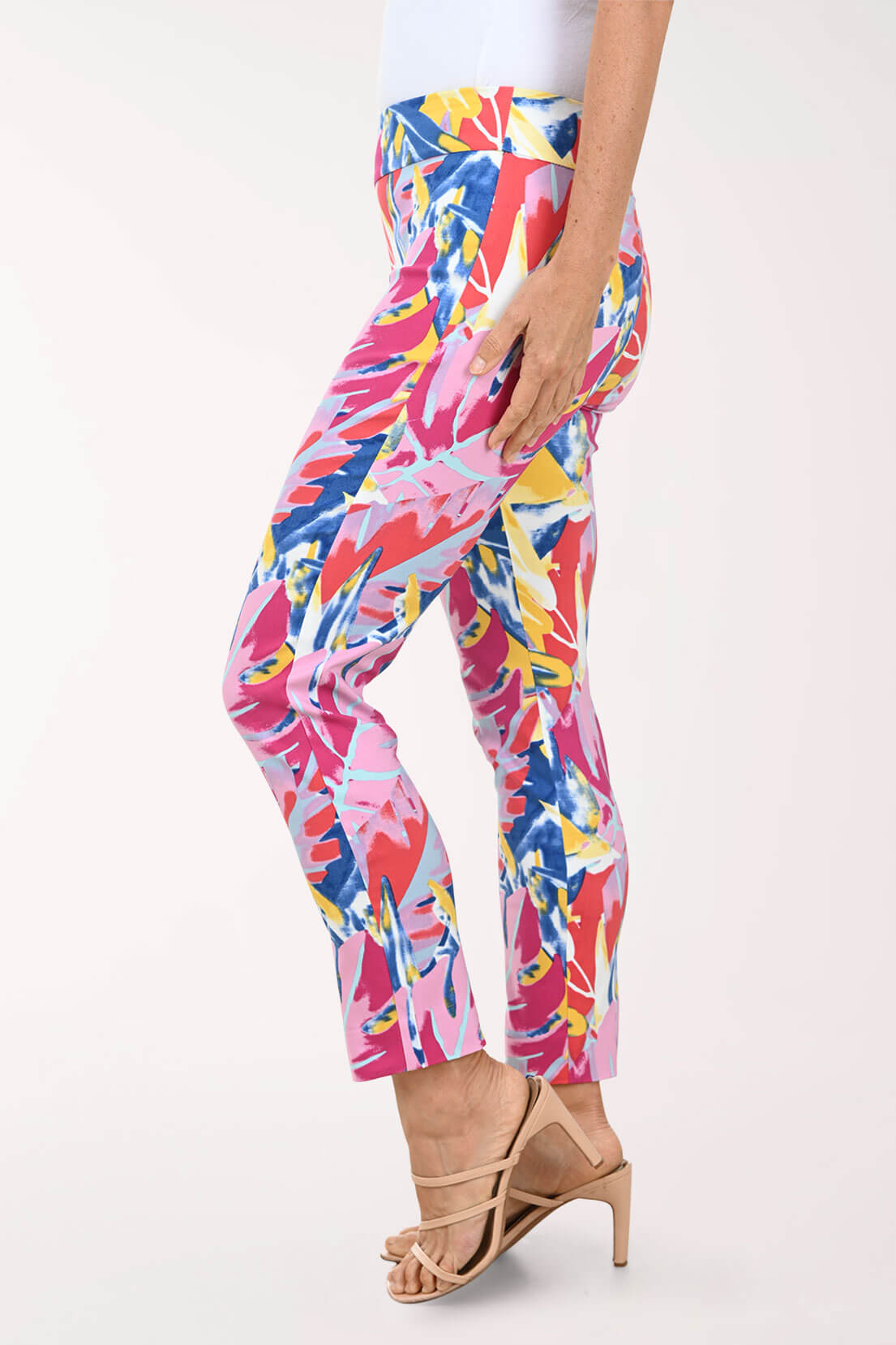 Multicolored tropical print pants worn by a person on a white background