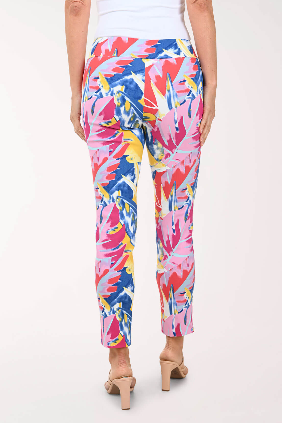 Multicolored tropical print pants worn by a person on a white background