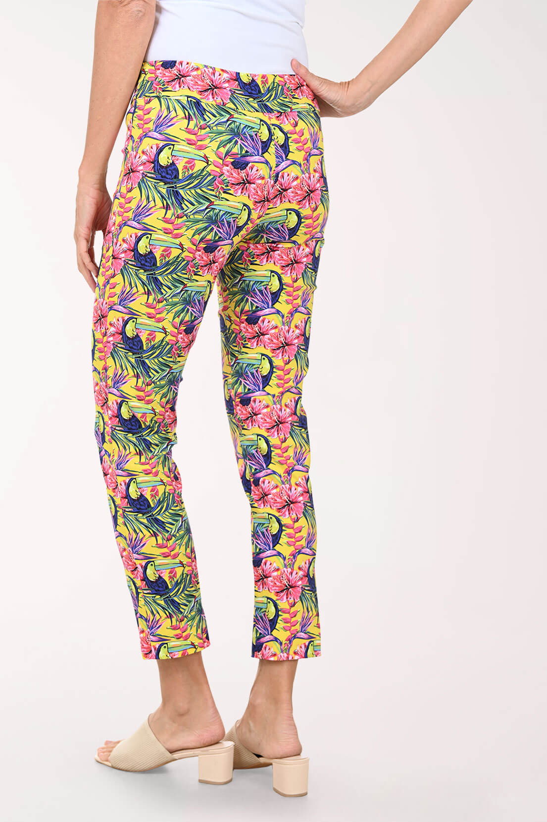 Tropical patterned pants worn by a person on a white background