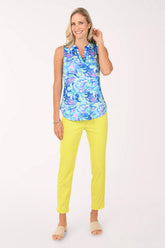 Woman wearing a colorful sleeveless top and yellow pants on a white background