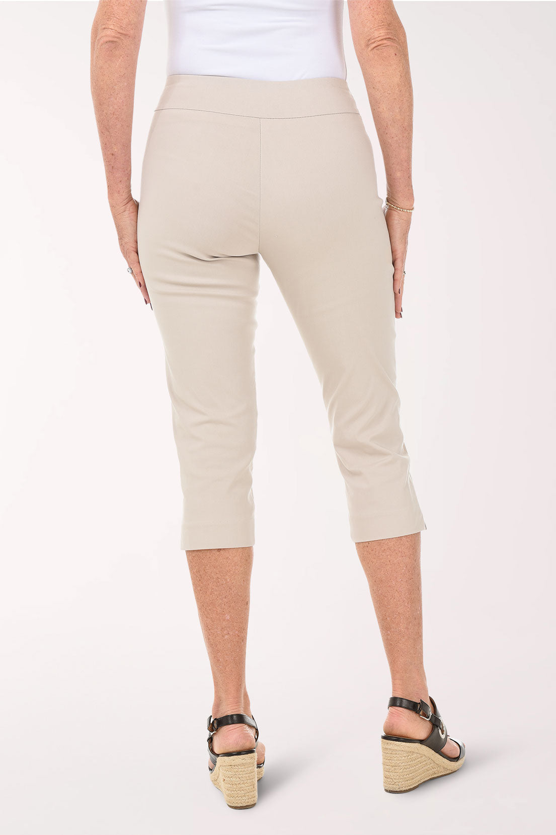 Beige capri pants worn by a person on a white background