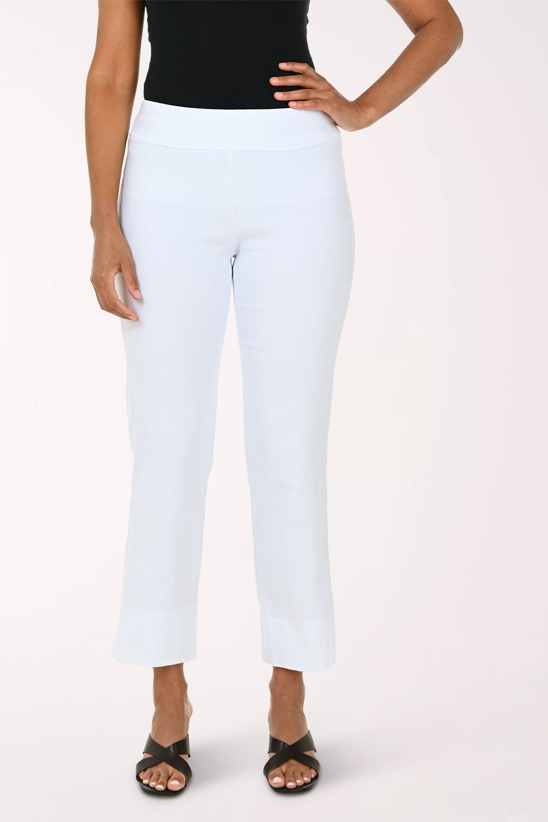 Person wearing white pants and a black top on a plain background