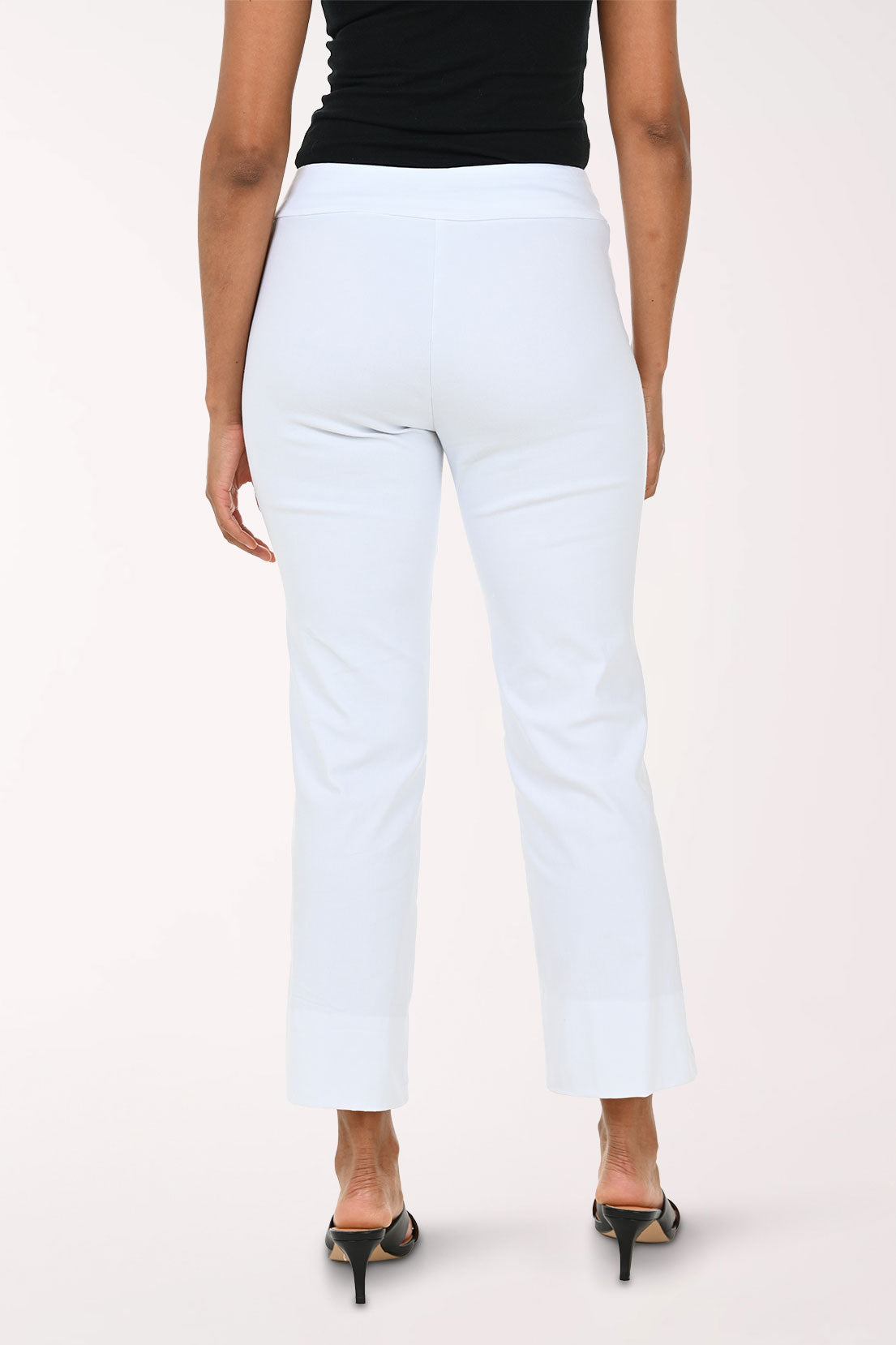 Person wearing white pants and a black top on a plain background