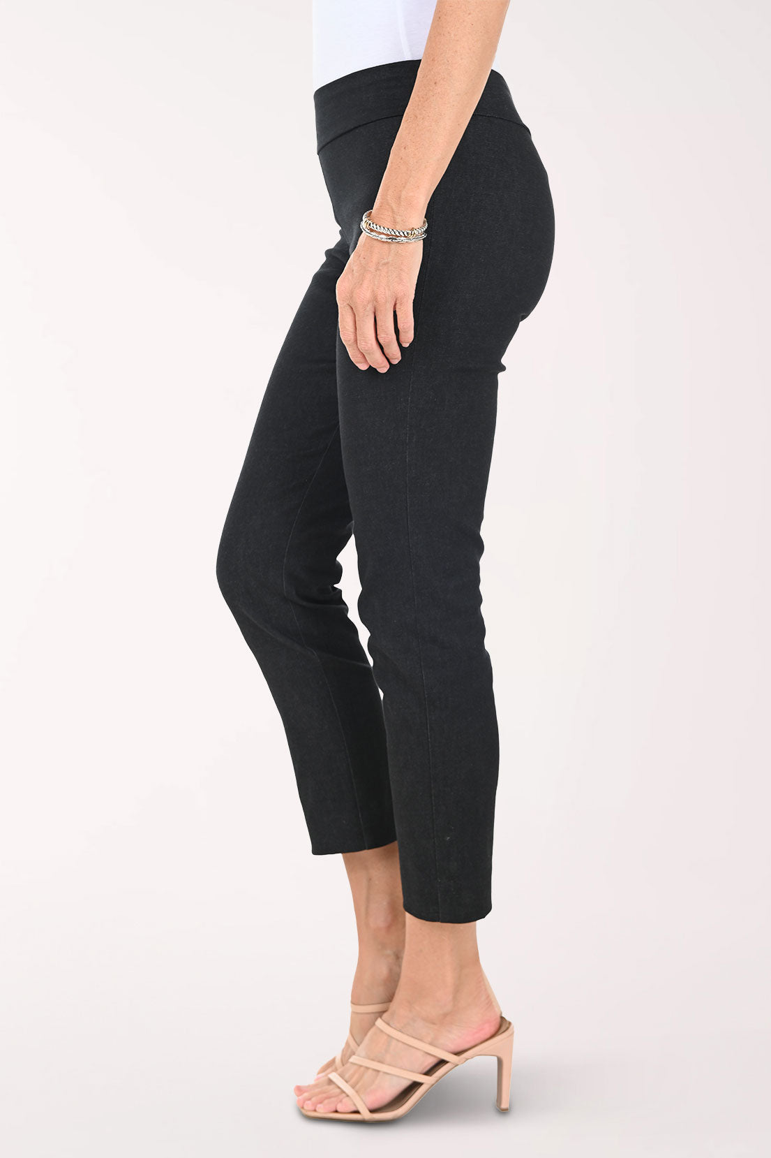 Slim black pants worn by a person on a white background