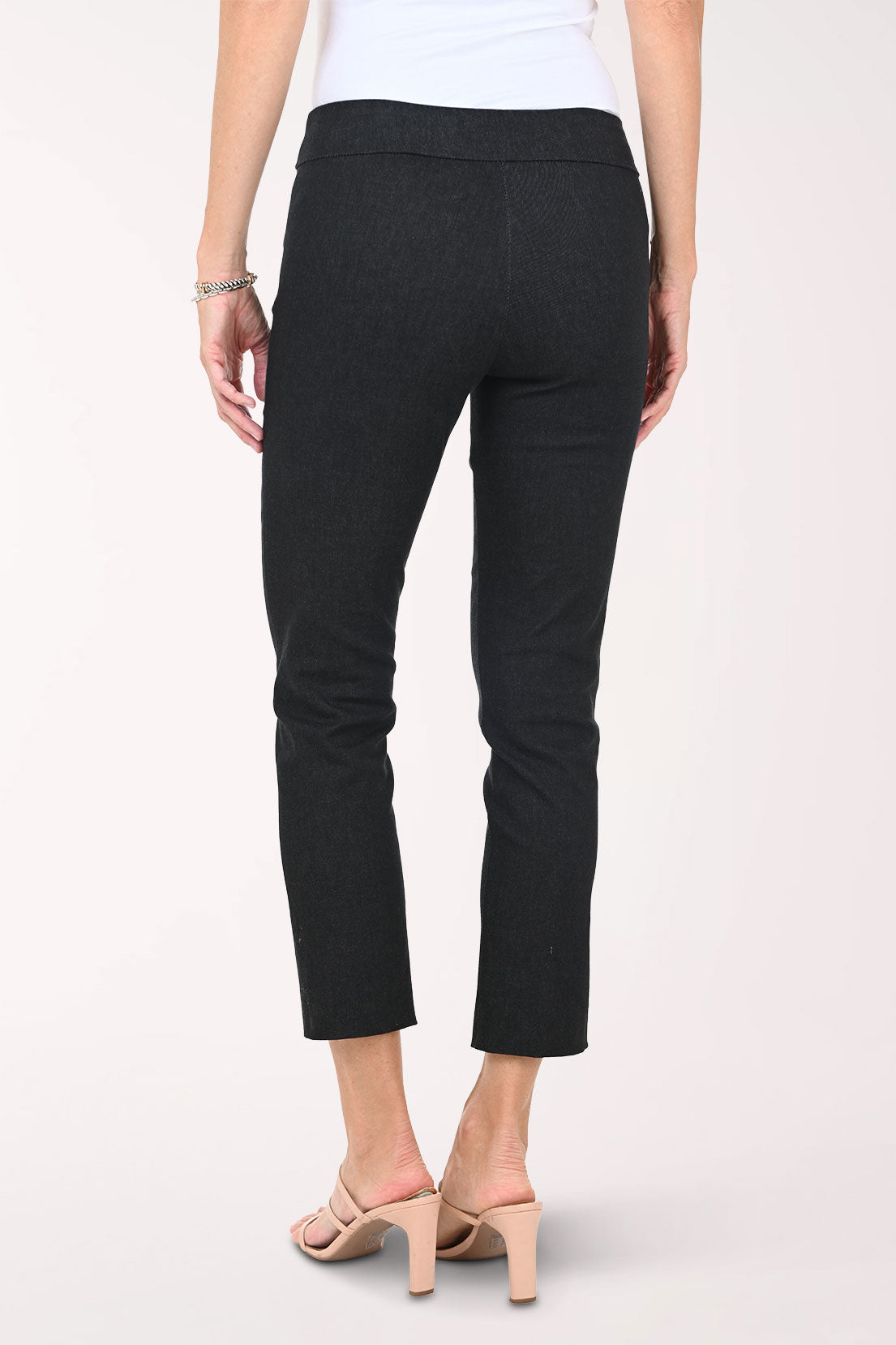 Slim black pants worn by a person on a white background