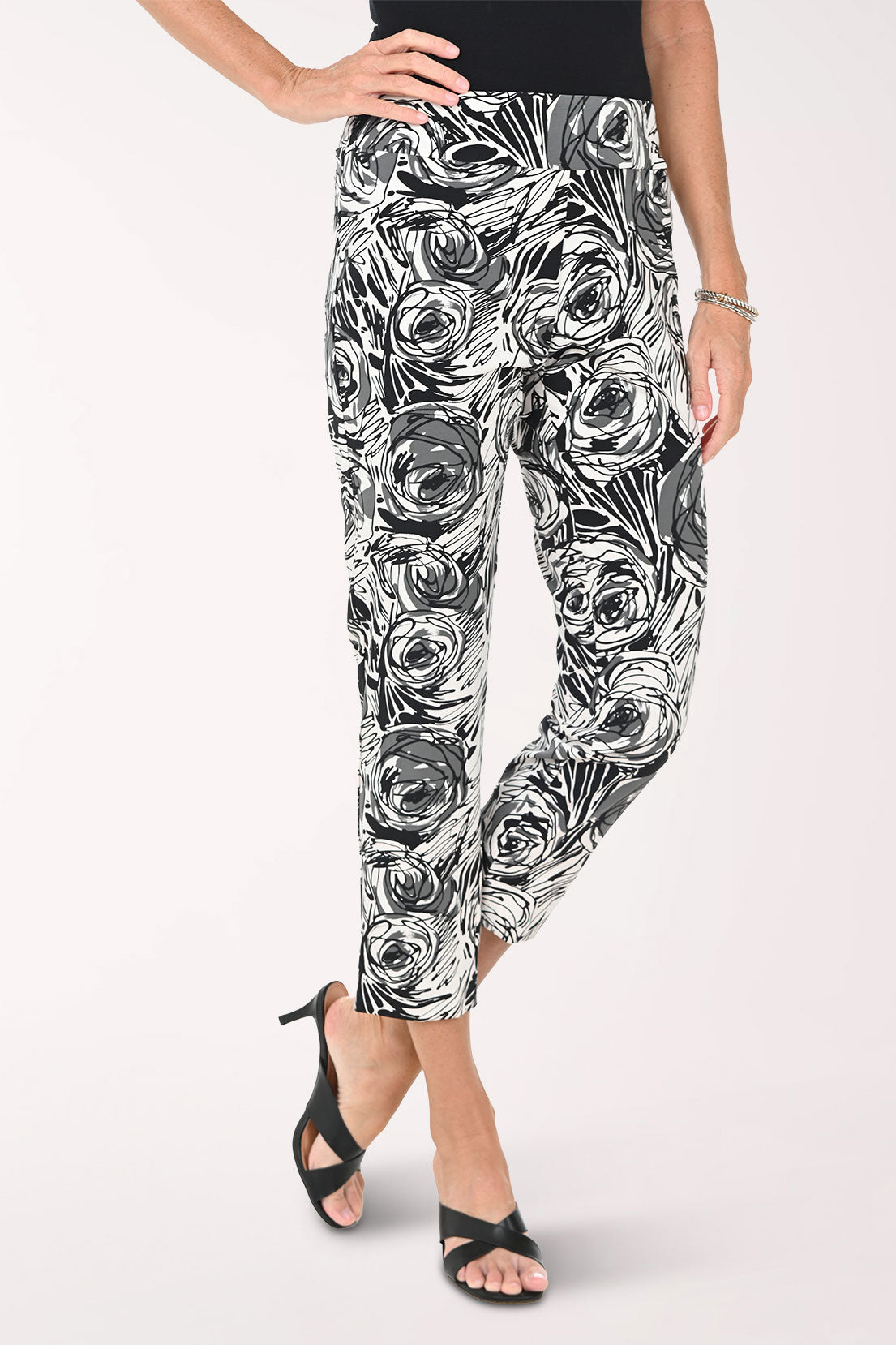 Woman wearing black and white floral patterned pants on a white background