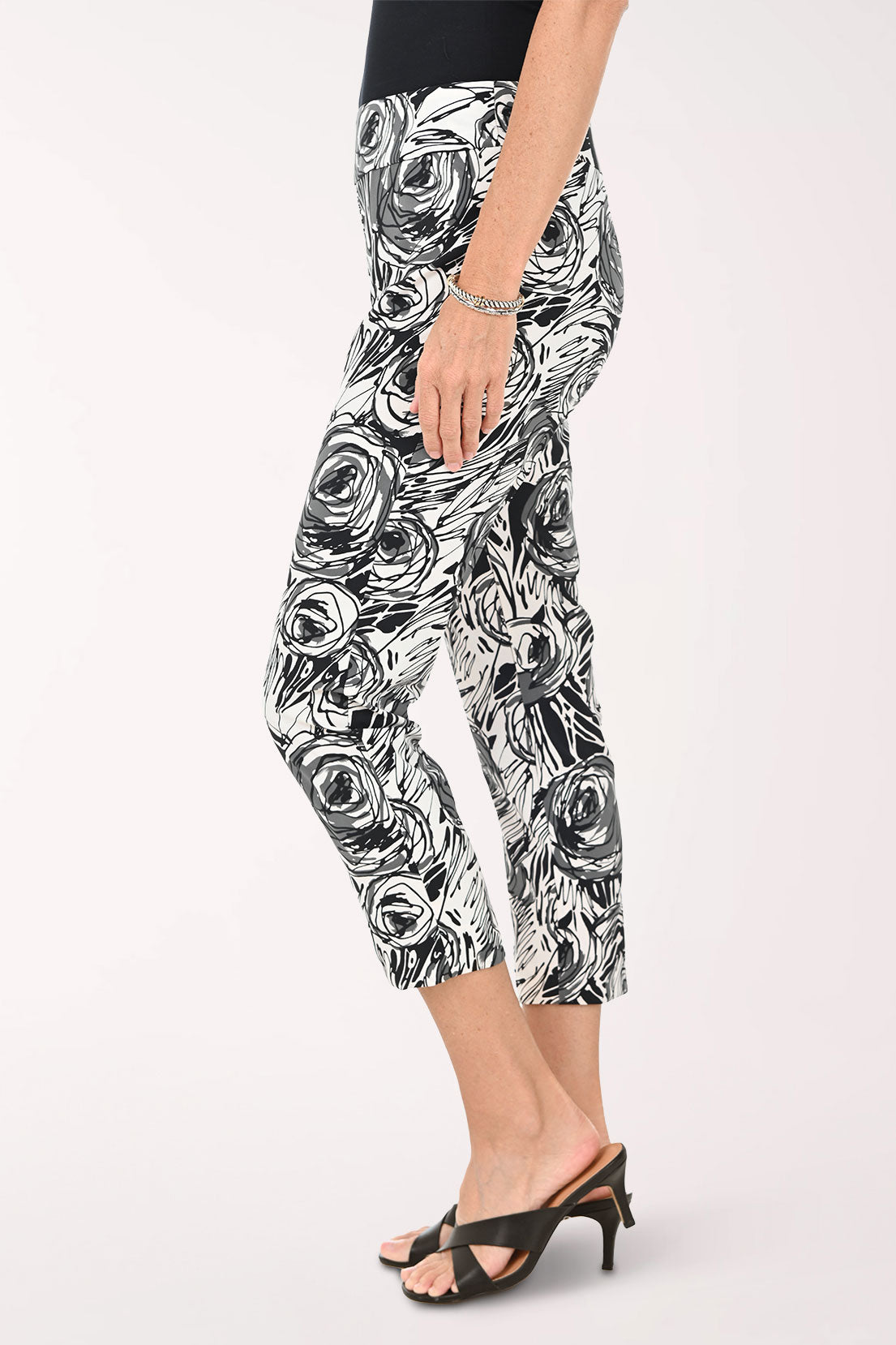 Woman wearing black and white floral patterned pants on a white background