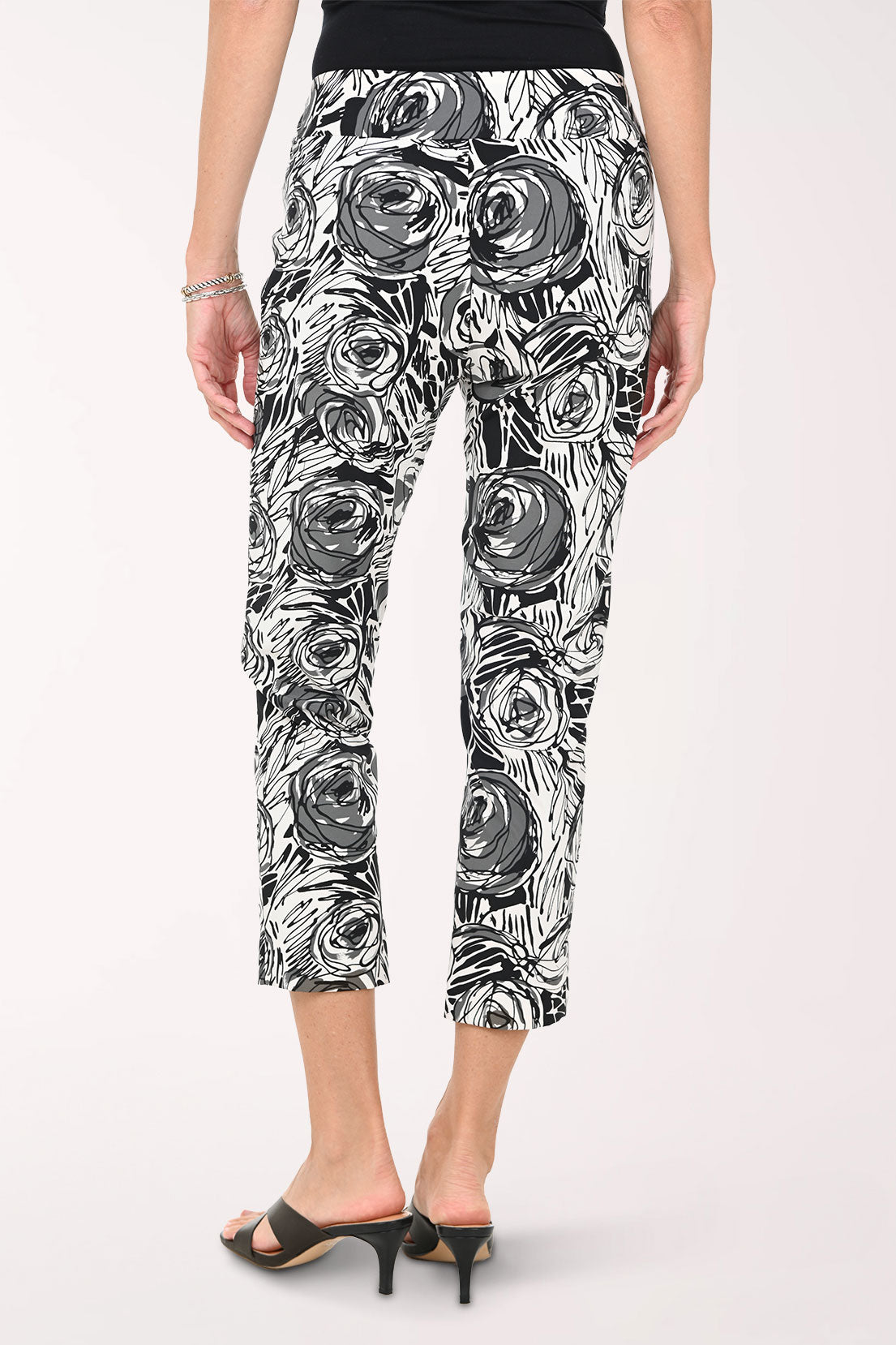 Woman wearing black and white floral patterned pants on a white background
