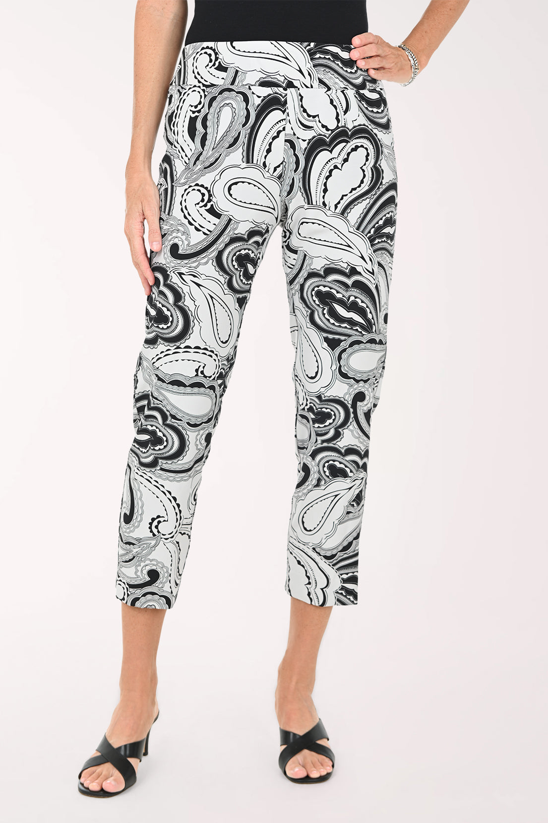 Person wearing black and white patterned pants on a white background