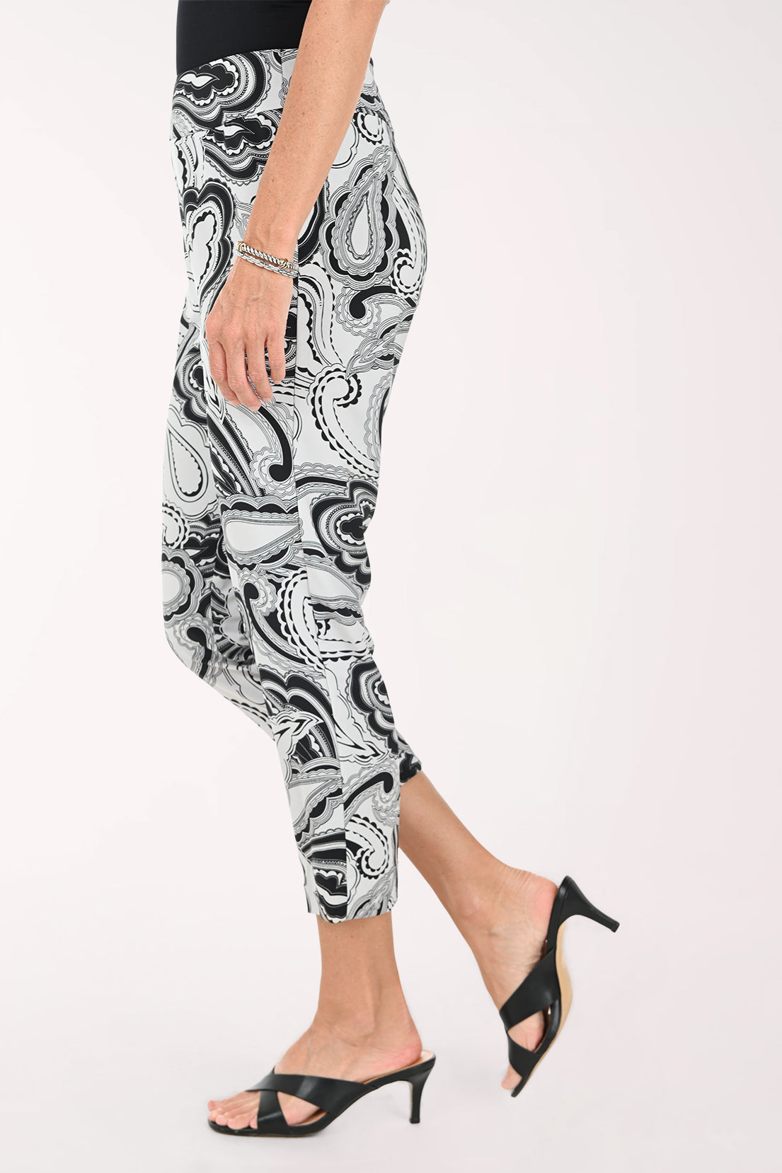 Person wearing black and white patterned pants on a white background