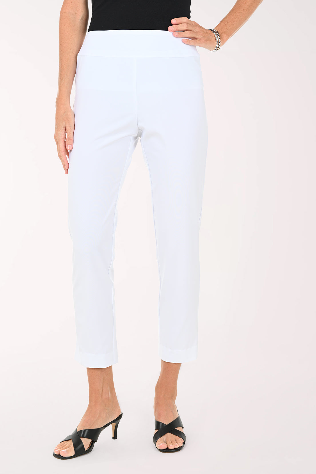 Person wearing white ankle pants on a white background