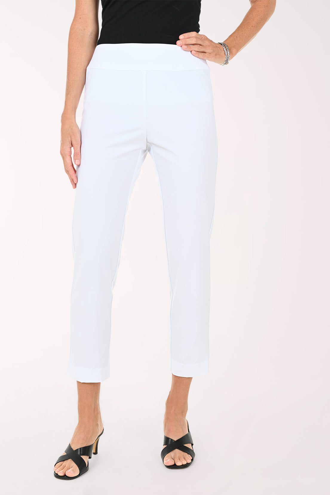 Person wearing white ankle pants on a white background