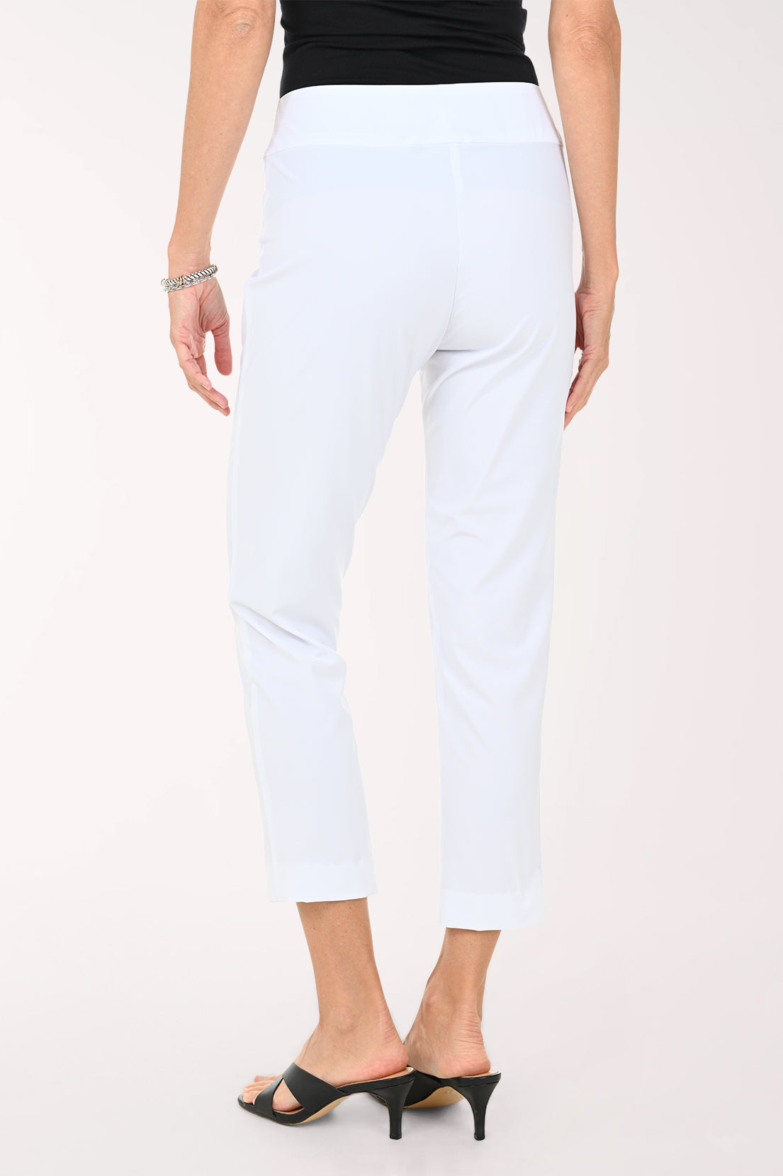 Person wearing white ankle pants on a white background