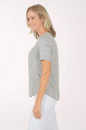 Woman wearing a black and white striped shirt and white pants on a white background