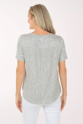 Woman wearing a black and white striped shirt and white pants on a white background