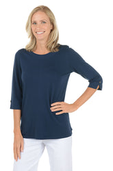 Woman wearing a navy blue top with rolled-up sleeves on a white background.