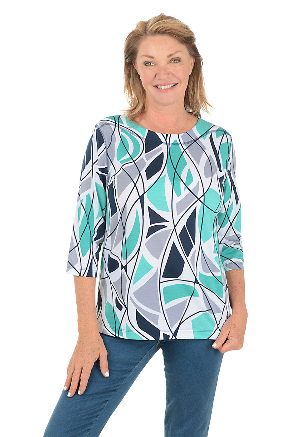 Woman wearing a blue colorful abstract patterned top and white pants on a white background.