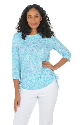 A woman wearing a 3/4 sleeve aqua top with ruched sides.