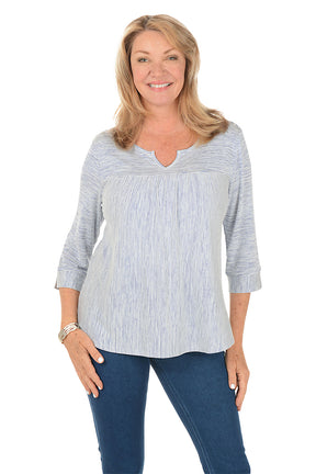 Woman wearing a blue and white striped shirt and blue jeans on a white background