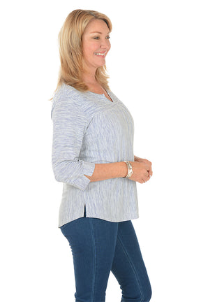 Woman wearing a blue and white striped shirt and blue jeans on a white background. Side shot.