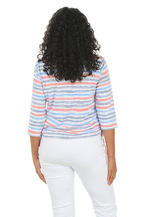Woman wearing a colorful striped top and white pants on a white background. Back shot.