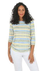 Woman wearing a striped long-sleeve top and white pants on a white background.