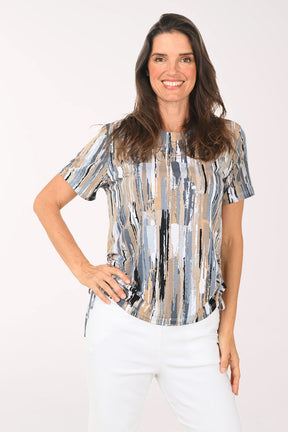 Woman wearing a patterned blouse and white pants on a white background