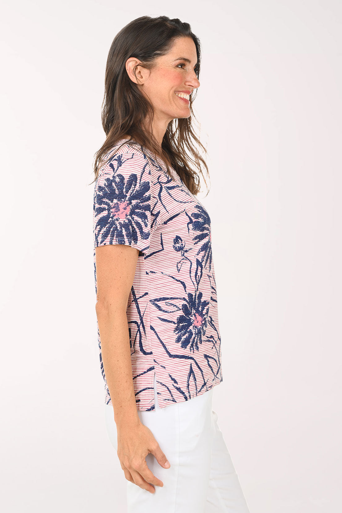 Woman wearing a pink and blue daisy print tee.