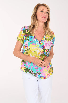 Woman wearing a multicolored orchid print short sleeve top