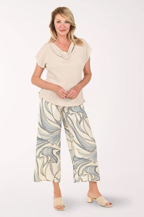Woman wearing a beige shirt and cropped beige pants