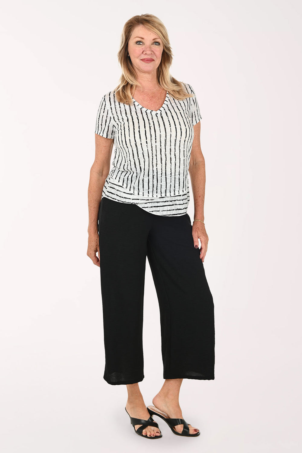 Woman wearing a black and white short sleeve tee and black flared crop pants