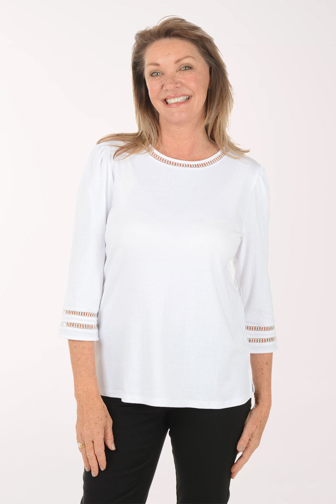 Woman wearing a white blouse with gold accents on a white background
