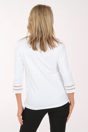 Woman wearing a white blouse with gold accents on a white background