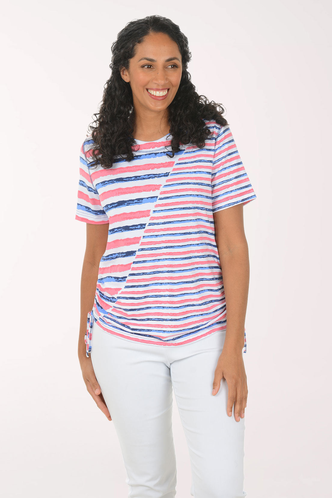 Woman wearing a striped shirt and white pants on a white background