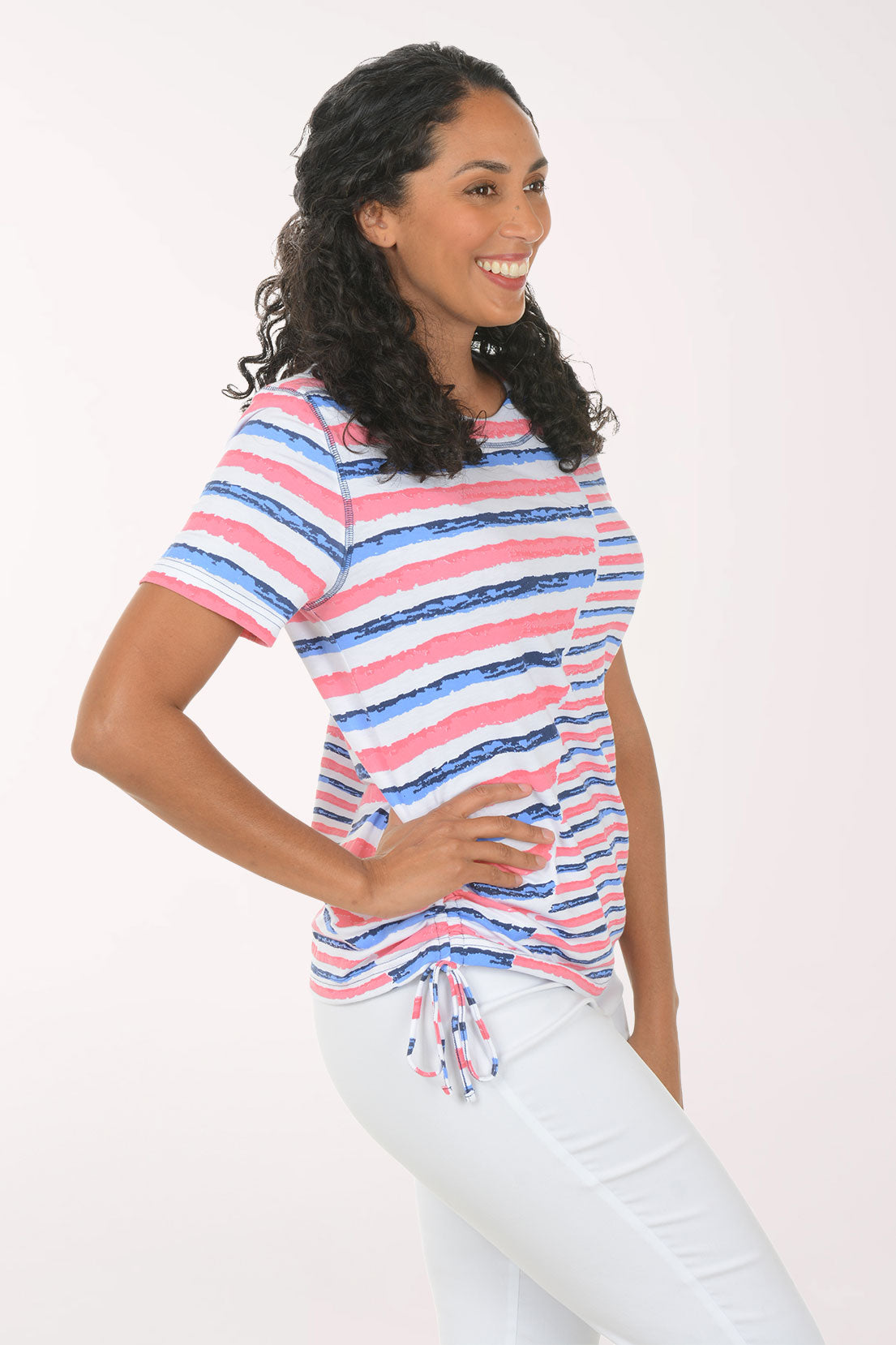 Woman wearing a striped shirt and white pants on a white background