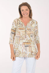 Woman wearing a patterned blouse with a plain background