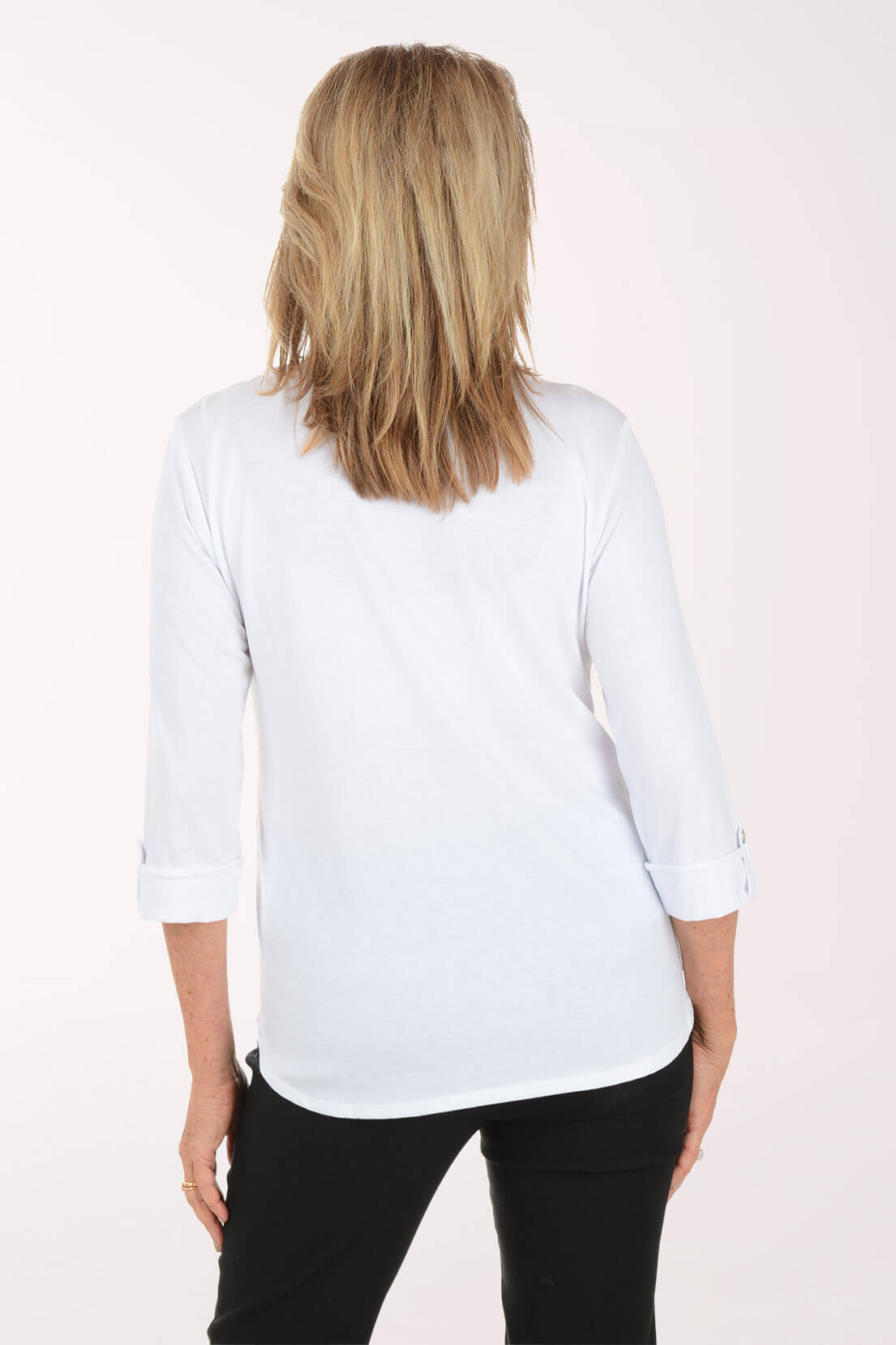 Woman wearing a white blouse with a subtle pattern on a light pink background