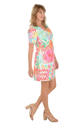 Woman wearing a colorful patterned dress on a white background